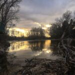 The Boise River at sunset, with a scenic landscape of water, sky, and forested surroundings in winter.