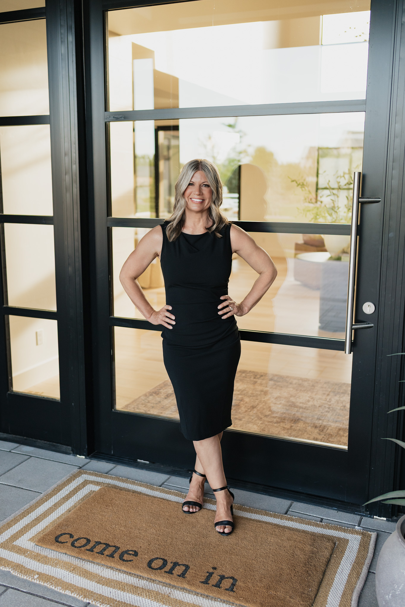 Tracie McDonald welcoming clients at the front door of a home
