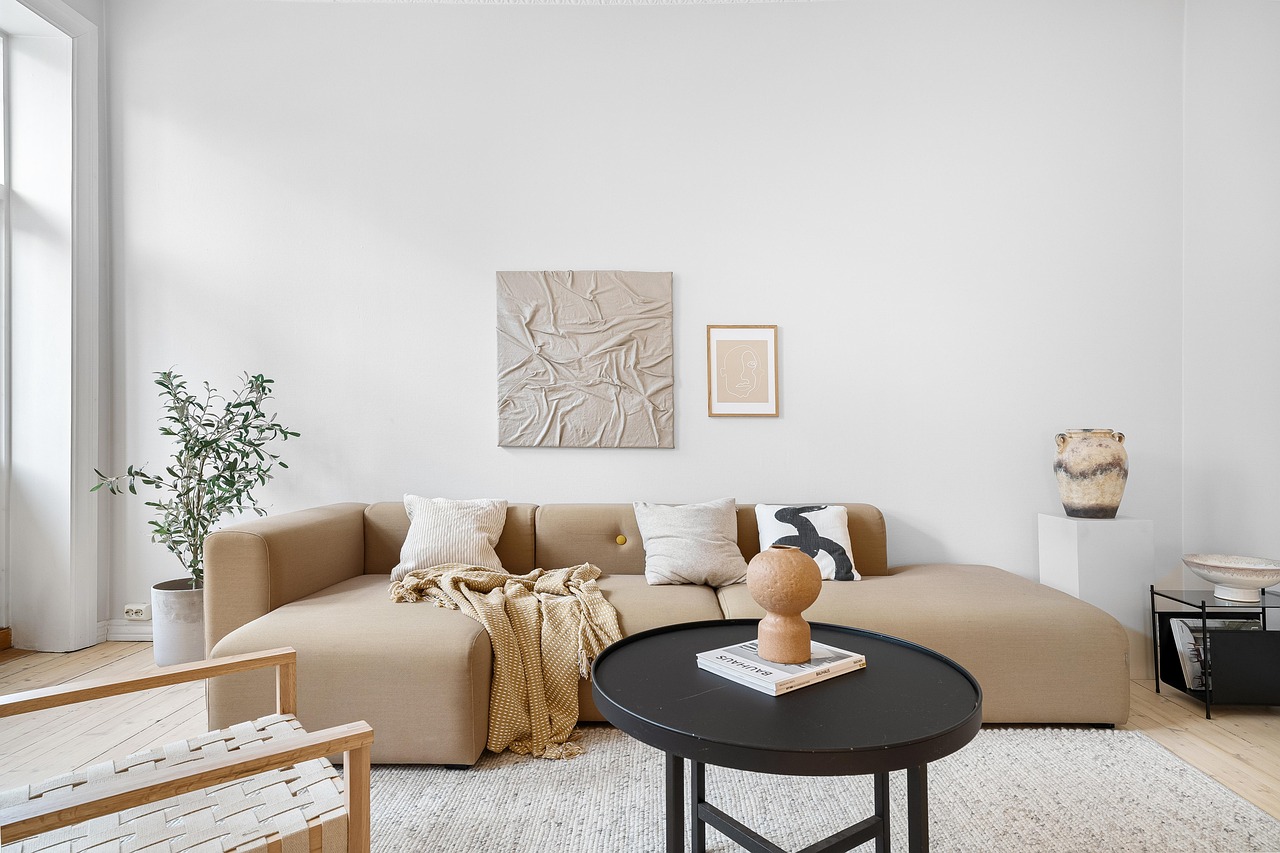 Warm, neutral living room staged with a tan sofa and round coffee table