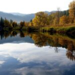 The Saint Maries River in North Idaho reflects fall foliage along its scenic, peaceful banks.