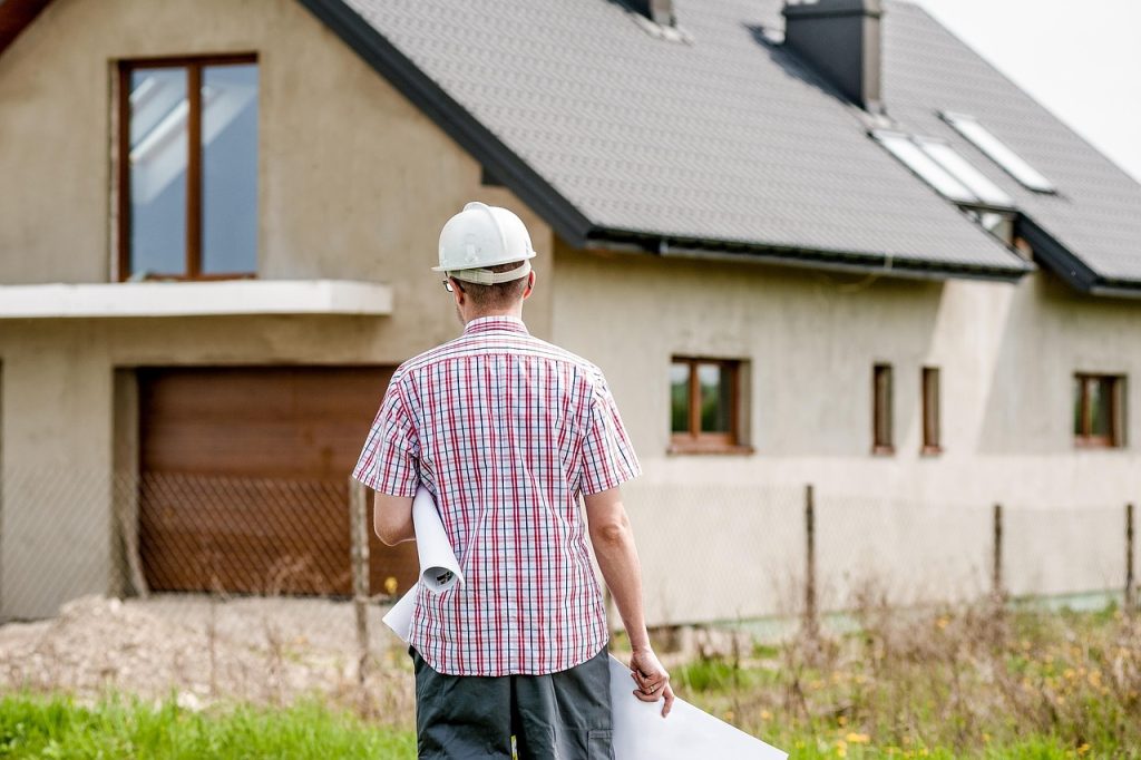 A person in a professional setting reviews building plans and documents related to home construction or development.