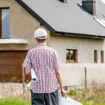 A person in a professional setting reviews building plans and documents related to home construction or development.