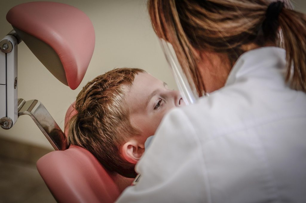 A person receiving a dental examination from a doctor in a dental clinic.