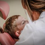 A person receiving a dental examination from a doctor in a dental clinic.