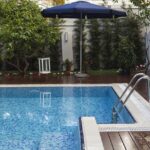 A luxury villa with a blue outdoor swimming pool and architectural exterior design.