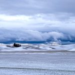 Snow-covered farmland in the Palouse region of Idaho during a stormy winter day.