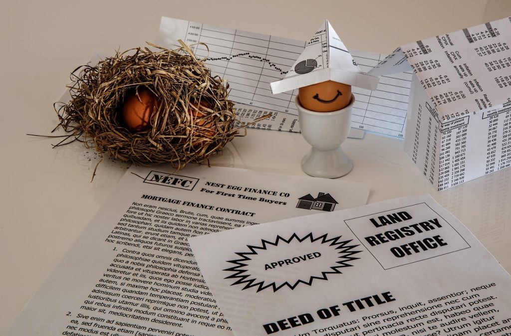 Finance documents, a mortgage contract, and savings materials arranged together representing a home loan process.