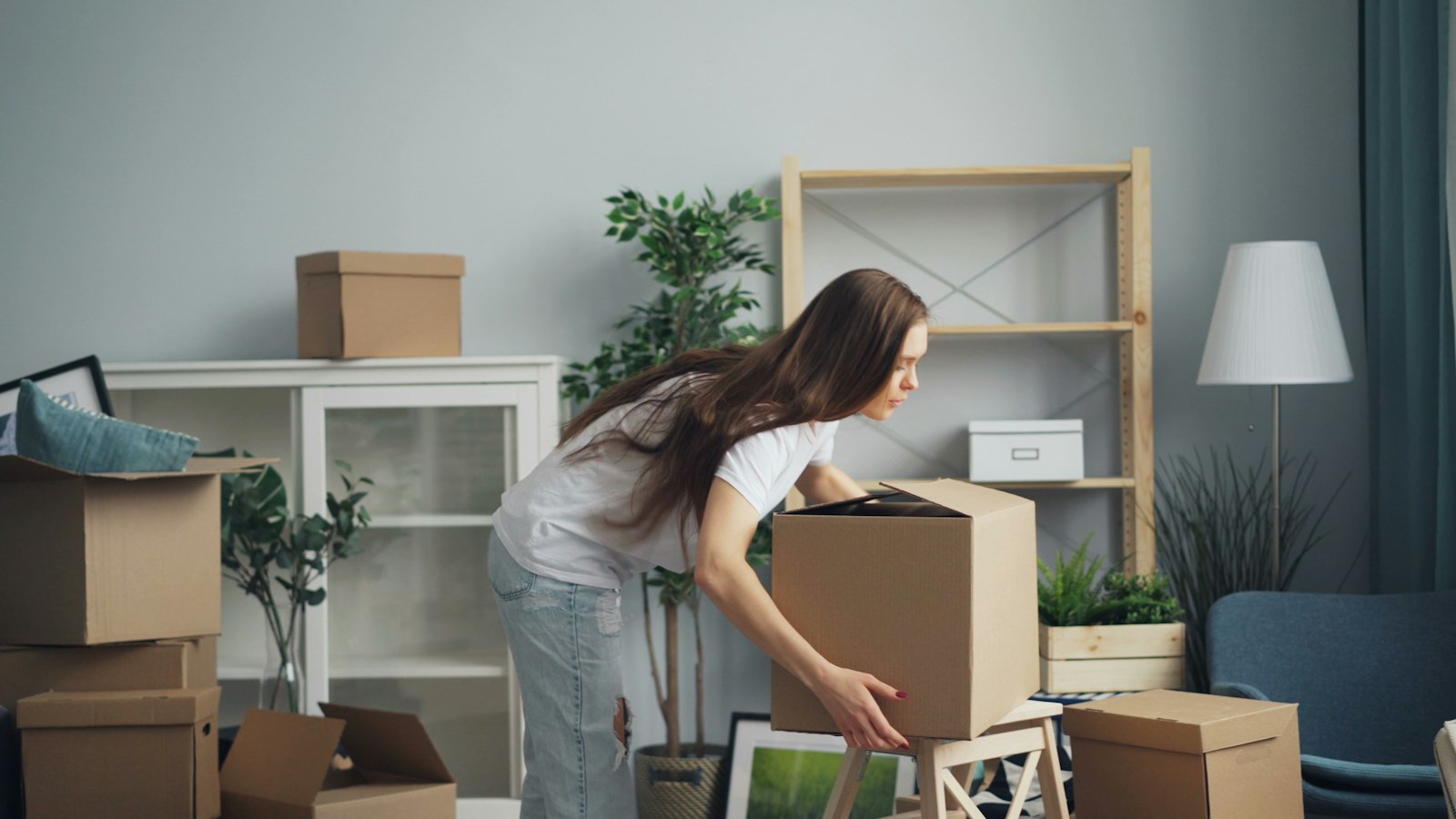Woman unpacking moving boxes after buying a home in Meridian, Idaho before moving